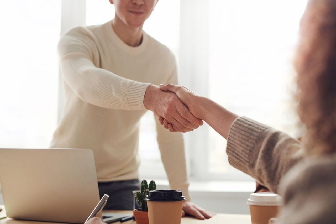 An expert and client shaking hands at the start of a consulting engagement